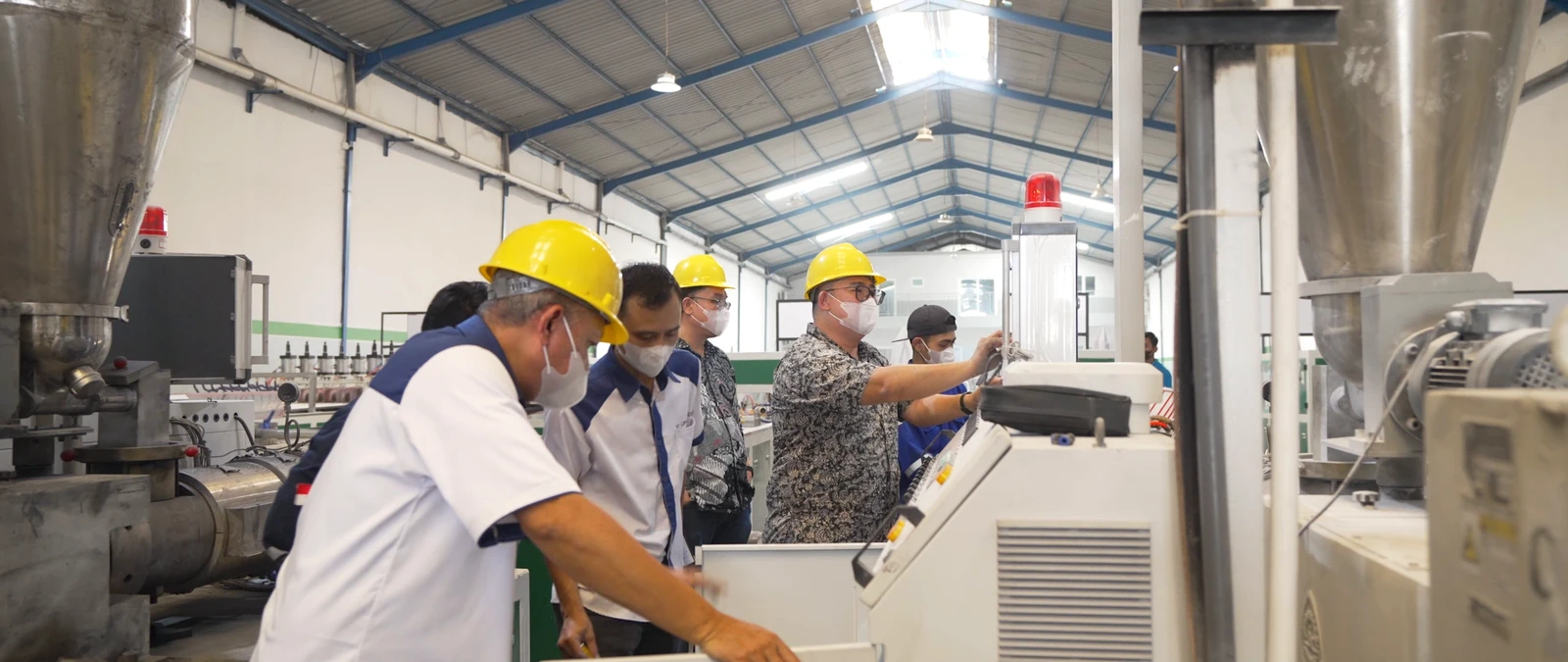 Tim mengamati mesin dan panel kontrol di area produksi UPVC.